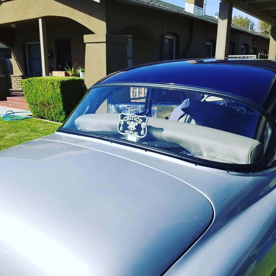Classic Cadillac parked in driveway with a new rear window